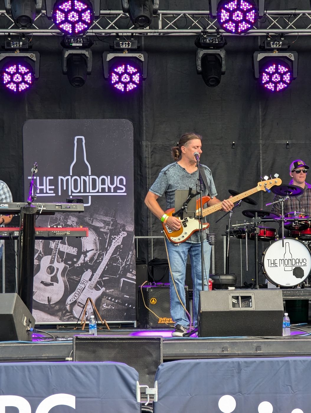 Denny Menter on stage playing bass with The Mondays
